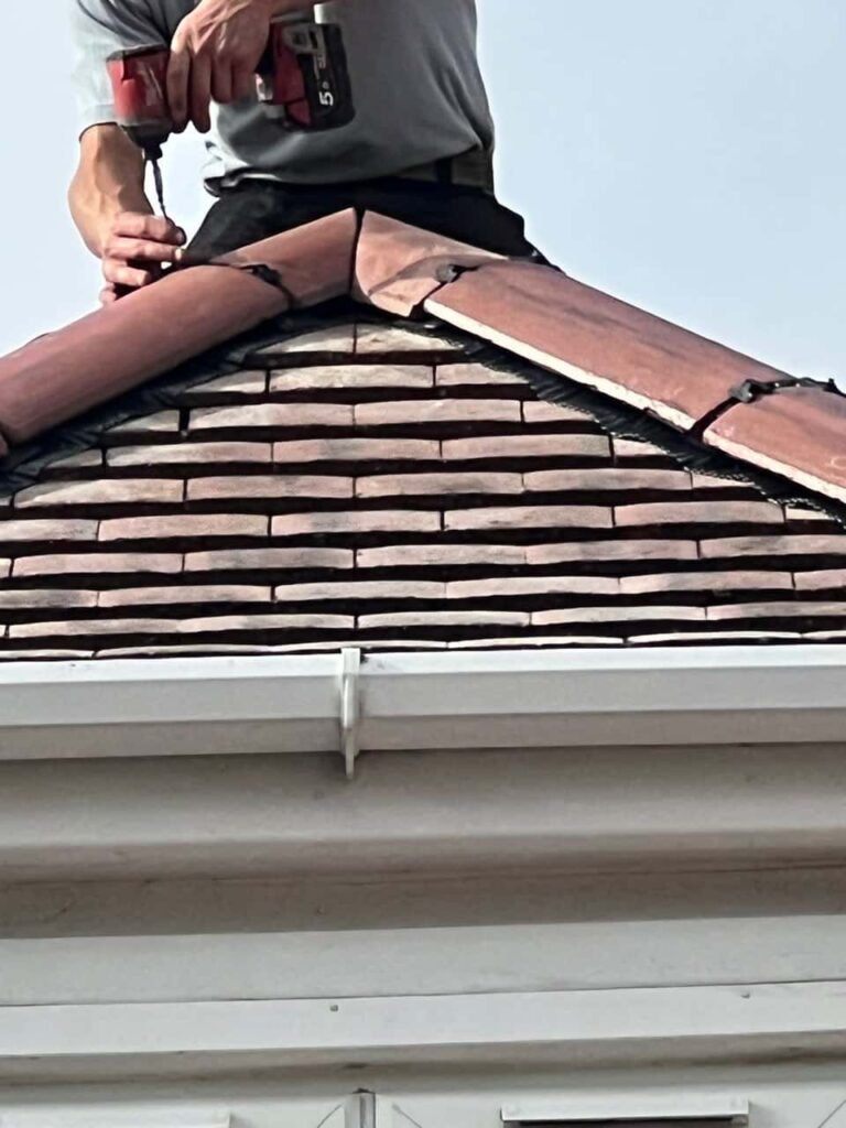 This is a photo of one of the operatives of MCM Roofing Repairs Ringwood installing new ridge tiles