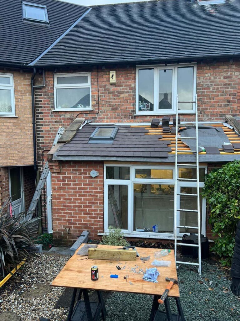 This is a photo of a roof extension that is having new roof tiles installed. This is a photo taken from the roof ridge looking down a tiled pitched roof on to a flat roof. Works carried out by MCM Roofing Repairs Ringwood